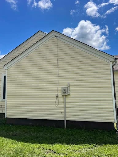 Painting project by Healthy Home Pros in Millington, Tennessee. The image shows a pale yellow siding exterior with white trim.